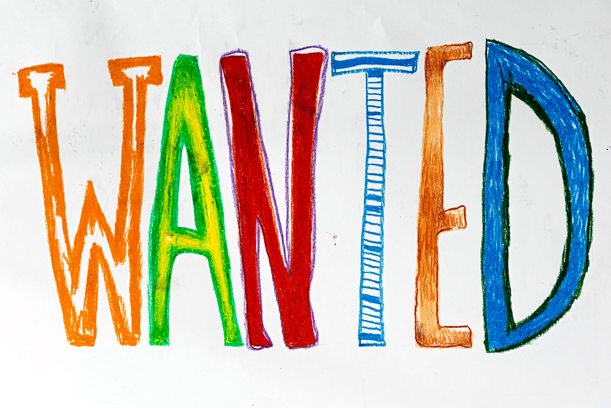 Detail: the word WANTED drawn in oil pastel, each letter a different colour.