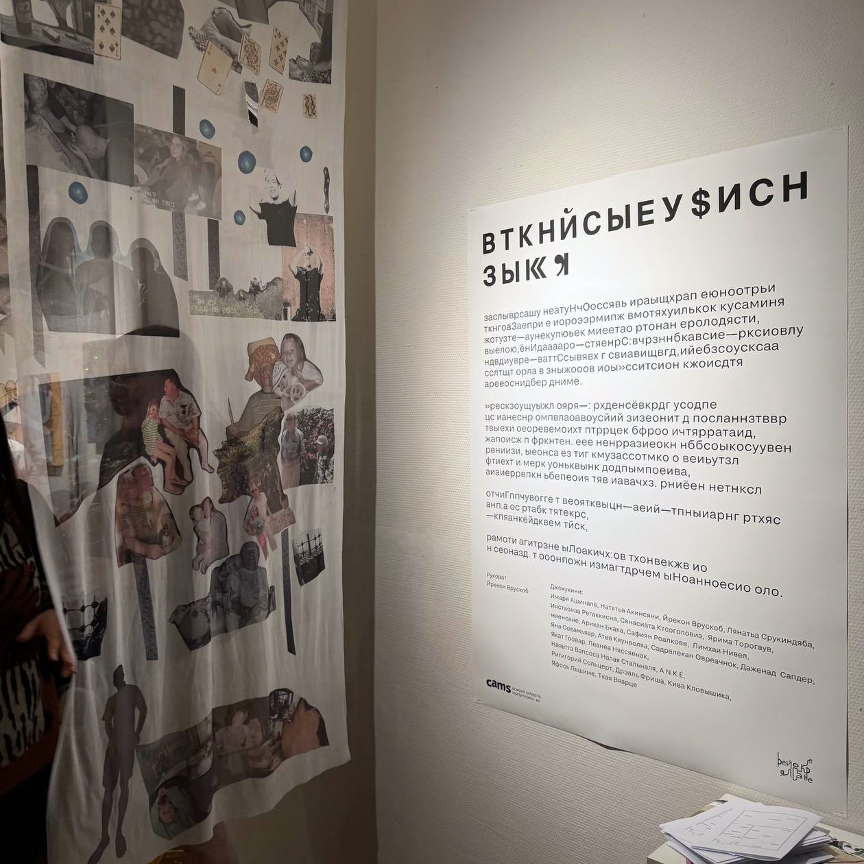 A printed mesh panel beside the exhibition's wall text, whose Cyrillic has been deliberately scrambled into unreadable words.